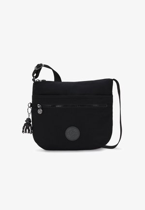 Black fabric shoulder bag with a flat design, adjustable strap, front zipper pocket, and a keychain monkey figurine detail.