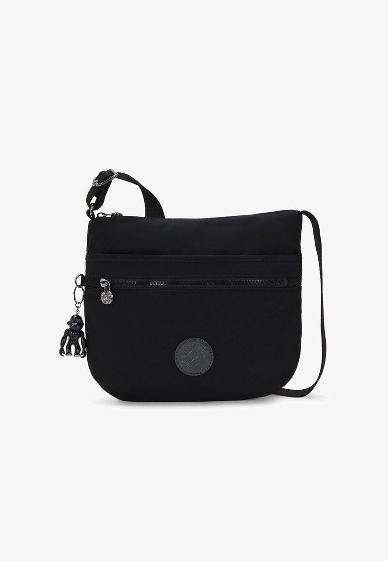 Black fabric shoulder bag with a flat design, adjustable strap, front zipper pocket, and a keychain monkey figurine detail.