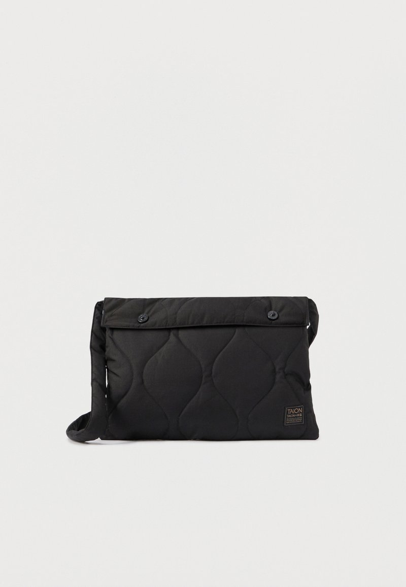 Crni preklopni messenger ruksak s flapom, dva prednja gumba i bočnom trakom. Ima teksturiranu površinu i malu oznaku logotipa.