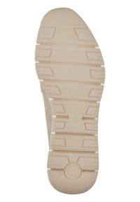 Vue par le bas d'une semelle de sneaker beige présentant une surface en caoutchouc texturé avec un motif de semelle pour une traction et une durabilité optimales.