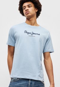 Ανοιχτό μπλε κοντομάνικο T-shirt από μαλακό βαμβάκι, με το λογότυπο "Pepe Jeans London" σε ναυτικό μπλε. Απλός σχεδιασμός με στρογγυλή λαιμόκοψη.