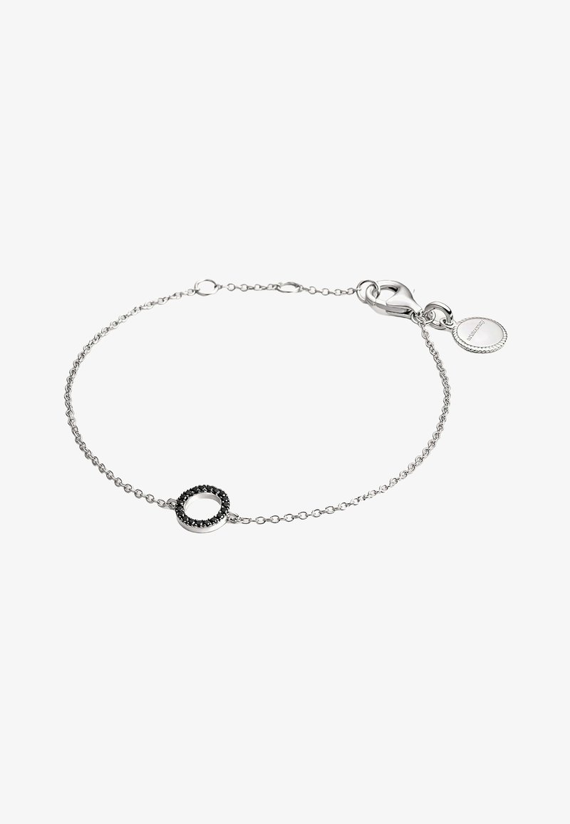 Pulsera de cadena de plata con un acento de piedra negra circular, con un cierre tipo langosta y una pequeña etiqueta redonda adherida.