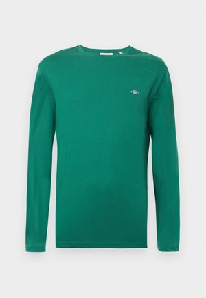 T-shirt à manches longues en coton vert vif ; doté d'un col rond et d'un petit logo brodé sur la poitrine ; texture lisse, coupe décontractée.