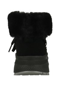 Zwarte schoen met een zachte faux fur kraag, bovenkant van suède, een gestructureerde rubberen zool en vetersluiting aan de achterkant. Geen zichtbare merknaam.
