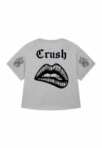 T-shirt gris avec un graphisme noir de lèvres mordant la lèvre inférieure, le mot "Crush" au-dessus, et des dés en flammes sur les deux manches.