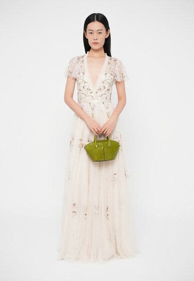 Kvetinovo vyšívané šaty s výstrihom do V a krátkymi priesvitnými rukávmi, doplnené zelenou koženou kabelkou s zaoblenými rúčkami.