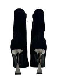 Stivaletti alla caviglia in suede nero dal design elegante, tacco alto metallizzato e chiusure con zip ai lati. Texture liscia con sottili dettagli di cucitura.