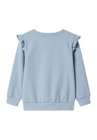 Zils džemperis ar volānu akcentiem uz pleciem, ribota aproču un apakšmalas apdare, izgatavots no mīksta auduma ar gludu struktūru. Attēlots no muguras puses.