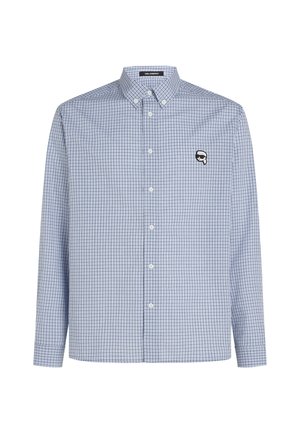 Chemise à manches longues à carreaux bleus et blancs, avec un col et un petit logo noir sur la poitrine. Tissu lisse.