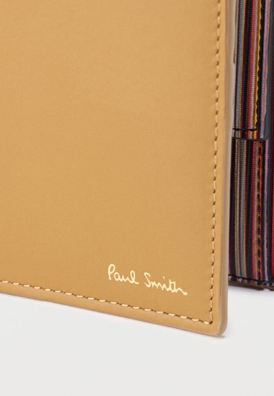 Καφέ πορτοφόλι από δέρμα με απαλή υφή. Διαθέτει ανάγλυφο λογότυπο «Paul Smith» σε χρυσό και πολύχρωμη ριγωτή εσωτερική επένδυση με ορατή ραφή.
