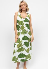 Abito maxi senza maniche in tessuto leggero, con uno sfondo bianco decorato da motivi di foglie verdi. Vestibilità ampia, scollatura rotonda, lunghezza fino al polpaccio.