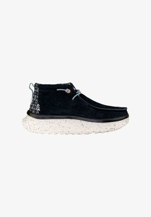 Bottines en daim noir avec des accents en textile à motifs, des lacets bleus et une semelle blanche mouchetée. Design léger et décontracté pour un usage polyvalent.