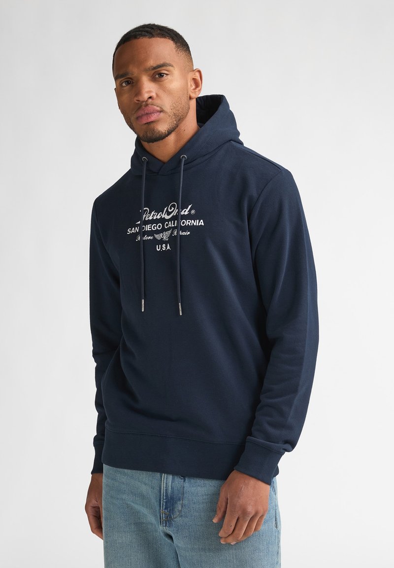 Sudadera con capucha de algodón azul marino con bolsillo tipo canguro, cordones y texto de logo impreso en blanco. Dobladillo y puños acanalados, ajuste holgado.