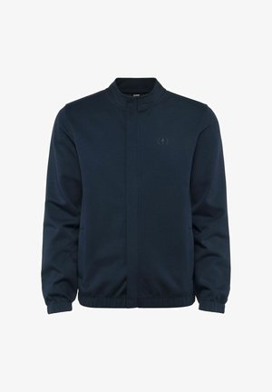 Granatowa kurtka bomberka z stójką, długimi rękawami, elastycznymi mankietami i zapięciem na zamek z przodu. Posiada subtelne logo na piersi.