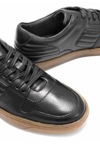 Czarne skórzane sneakersy o gładkiej fakturze, z okrągłym noskiem, sznurowaniem i gumową podeszwą dla lepszej przyczepności. Obecne akcenty na bocznych panelach.