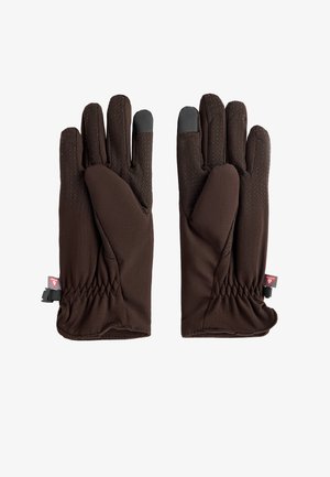 Para brązowych rękawiczek z teksturowanymi kropkami zwiększającymi chwyt i czarnymi końcówkami palców wskazujących kompatybilnymi z ekranami dotykowymi, elastyczne mankiety i małe czerwone metki.