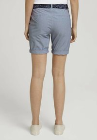 Pantalones cortos a rayas azules con dobladillo, con una cinturilla estampada y dos bolsillos en la parte posterior. El material es ligero y de estilo casual.