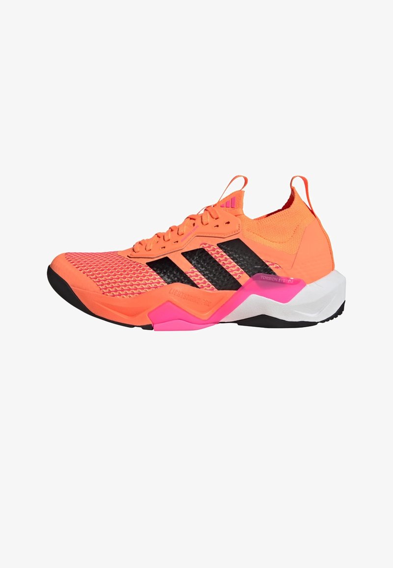 Chaussure de sport orange vif avec empeigne en mesh, accents noirs, détail de milieu de semelle rose, et semelle texturée, conçue pour la performance et le soutien.