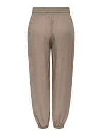 Pantalon de jogging beige avec taille et chevilles élastiques, coupe décontractée, en tissu léger.