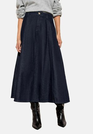 Dark blue denim skirt with a flared design, featuring a front button closure and visible stitching, paired with knee-high black boots.