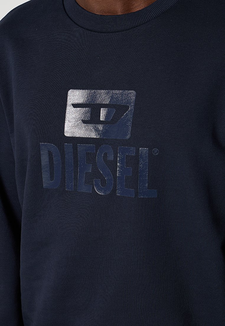 Felpa blu navy in cotone felpato, con logo Diesel in rilievo argentato sul petto. Collo a girocollo a costine.