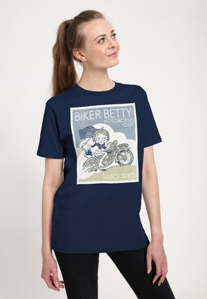 T-shirt bleu marine arborant un design graphique avec le texte "Biker Betty Motorcycle Club" et une illustration d'un personnage de dessin animé sur une moto.