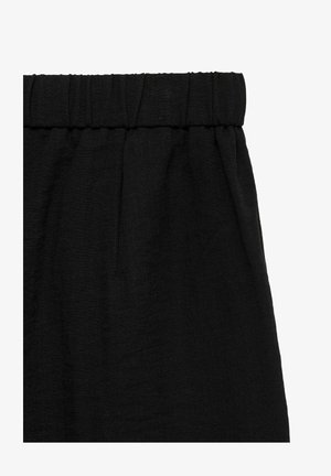 Pantalon en tissu noir avec taille élastique et texture subtile, montré en gros plan.