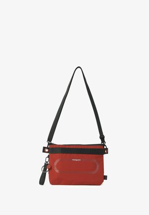 Sac bandoulière rouge Hedgren avec sangle noire réglable et porte-clés attaché sur le côté.