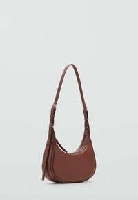 Bolso de hombro de cuero marrón con forma curvada, correa ajustable y costuras visibles. Presenta una textura suave y acentos de herrajes en tono dorado.