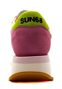 Sneaker multicolore con tallone in suede viola, accento in tessuto verde e una suola stratificata bianca e rosa con parte inferiore arancione.