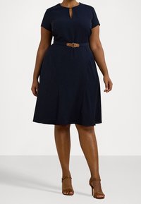Navy knee-length dress with a round neckline, short sleeves, and a keyhole detail. Features a belted waist and flared skirt design.