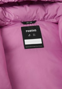 Interno di giacca isolante rosa con etichetta che mostra "reima", taglia 128 e simboli di cura su uno sfondo nero. Texture liscia.