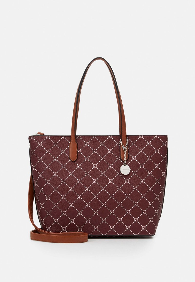 Sac fourre-tout bordeaux avec un motif en diamant et des poignées en cuir marron, avec une bandoulière amovible et un charm rond en argent sur une chaîne.