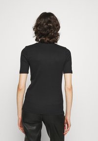 Czarny prążkowany top z krótkim rękawem o dopasowanej sylwetce i wysokim dekolcie, wykonany z elastycznego materiału dla wygody i eleganckiego wyglądu.