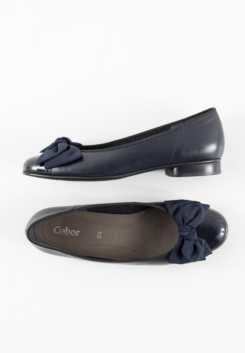 Ballerines navy à bout rond, avec un accent en nœud en tissu, un embout brillant et une semelle en caoutchouc flexible pour le confort.