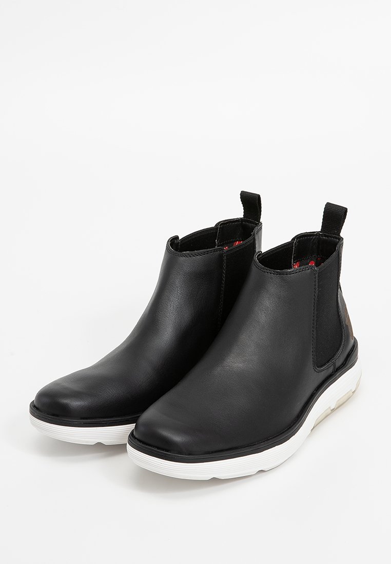 Schwarze Leder-Ankle-Boots mit elastischen seitlichen Einsätzen und Zugschlaufen. Weiße Sohle mit strukturierten Details. Glatte Oberfläche und runde Zehenform.