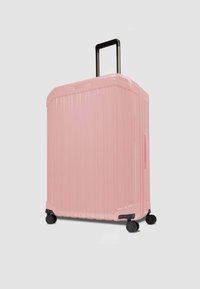 Valigia rigida rosa con scanalature verticali, manico nero retrattile e quattro ruote nere per facilitare la mobilità.