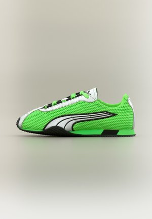 Baskets en maille vert néon avec logo Puma noir et blanc, semelle profilée basse, et accents noirs et verts, vues de côté sur un fond neutre.