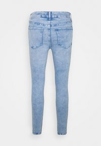 Jeans ajustados de color azul claro, hechos de denim, con un clásico diseño de cinco bolsillos y un sutil desgaste, con una silueta sencilla.
