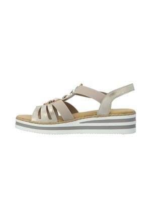 Beige sleehak sandaal met elastische banden, decoratieve edelstenen bovenop, gevoerde binnenzool en een dikke zool met witte en grijze strepen.