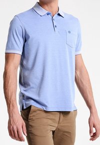 Polo bleu clair en coton, avec un col boutonné, des manches courtes à bordure contrastante et une poche poitrine.