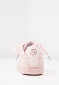 Tenisky Puma v měkké růžové nubukové a kožené kombinaci, s texturovanou podrážkou, stužkovými tkaničkami a logem na patě.