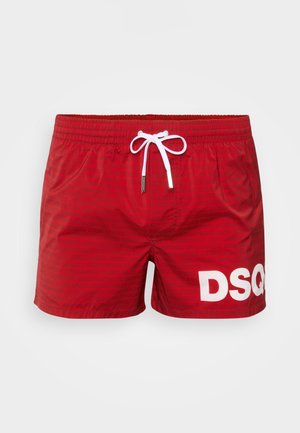 Red swim shorts made of lightweight fabric, featuring a subtle pattern and a prominent white "DSQ" logo on the side. Drawstring waist closure.