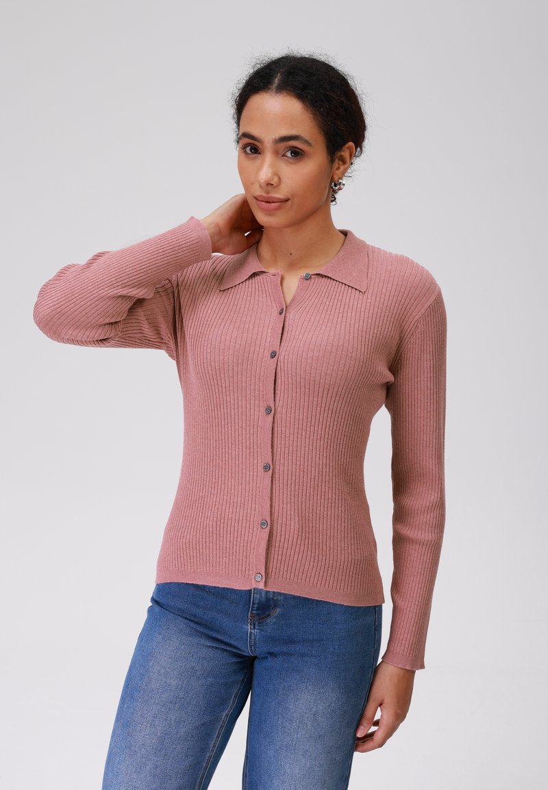 Rožinis raštuotas kardiganas su apykakle, ilgomis rankovėmis ir mygtukų uždarymu priekyje. Minkšta medžiaga ir tekstūruotas paviršius.