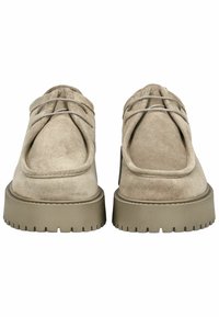 Scarpe in suede beige con punta arrotondata e suola in gomma spessa, caratterizzate da un design di lacci distintivo sulla parte anteriore.
