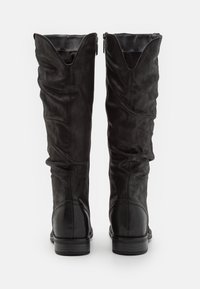 Botas de cuero negro hasta el tobillo con un diseño arrugado, punta redonda y un tacón bajo y apilado. Presentan un cierre de cremallera en el lado interno.