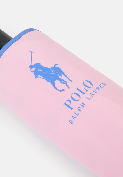 Ροζ υφασμάτινη θήκη κρασιού με λογότυπο μπλε παίκτη πόλο και το κείμενο "POLO RALPH LAUREN". Μαλακή υφή, με μπλε λεπτομέρειες.