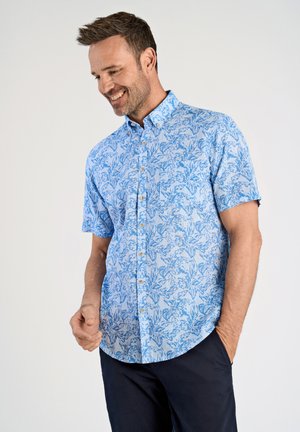 Chemise à manches courtes en tissu bleu clair avec un motif floral en bleu plus foncé. Col boutonné et coupe décontractée.