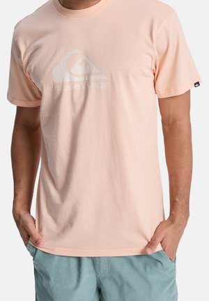 Licht perzikkleurig katoenen T-shirt met een wit grafisch logo op de borst, korte mouwen en een relaxte pasvorm.