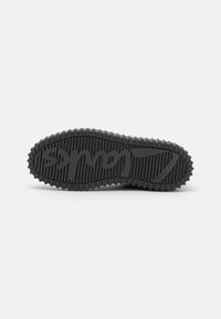 Sort gummisål til sneakers med ribbet tekstur, prydet med forhøjede bogstaver. Designet er fladt med afrundede kanter og et kontinuerligt mønster.